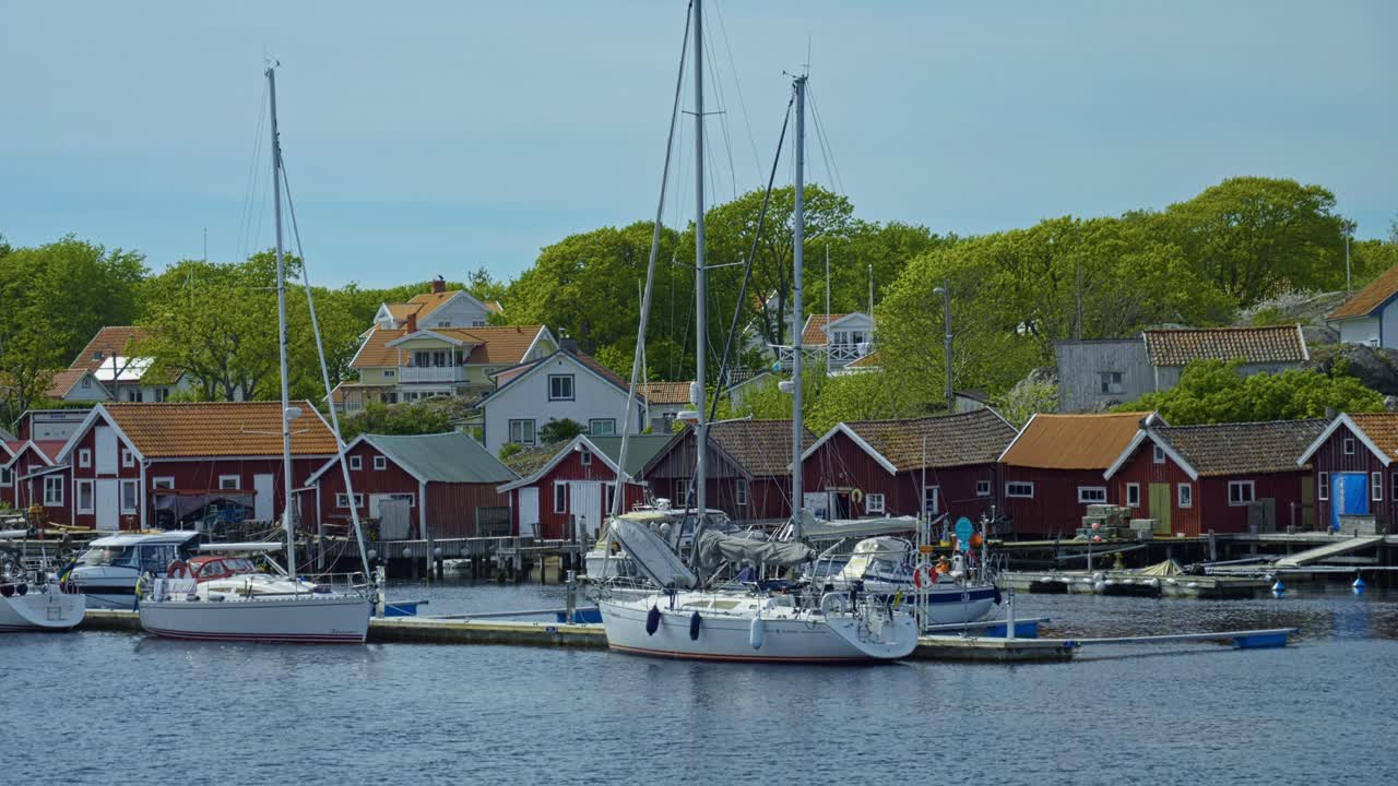 Idyllic Swedish archipelago with boats docked near red houses and lush greenery