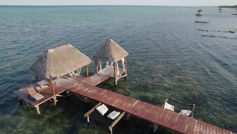 Orbit-shot-of-halls-in-front-of-the-resort-at-Akiin-Beach,-Tulum,-Mexico_drone-view