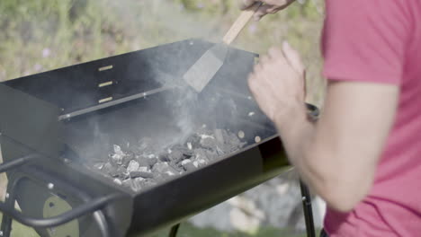 close-up of man feeling heat over barbeque grill