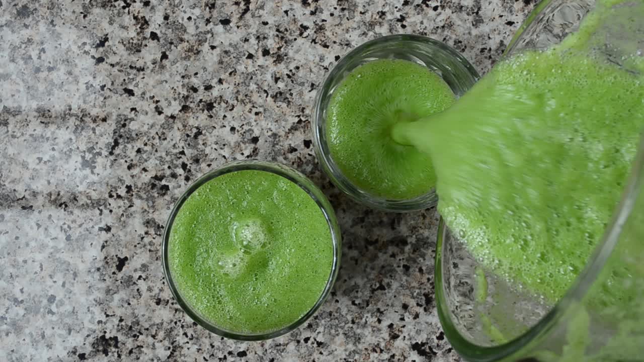 Cocktail di cetriolo, menta e lime. Il cocktail viene versato nei bicchieri.
