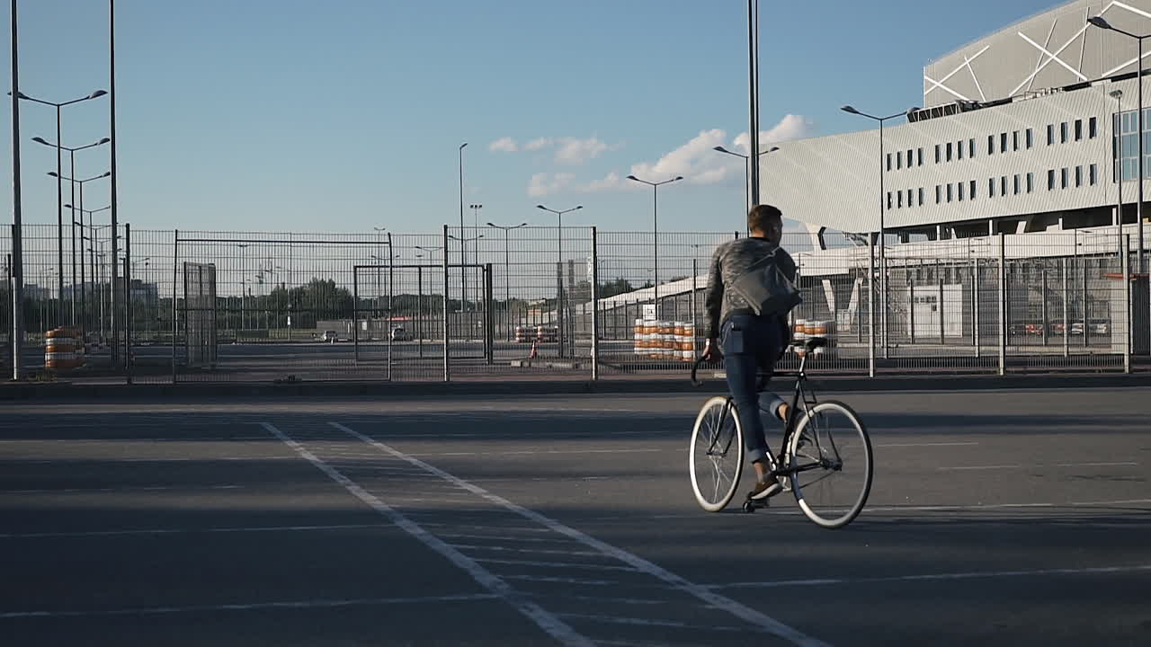 Man riding a bicycle in a parking lot