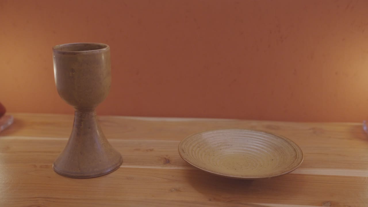 cáliz de porcelana marrón y paten - adornos sagrados en el altar de madera para la misa católica - tiro de dolly