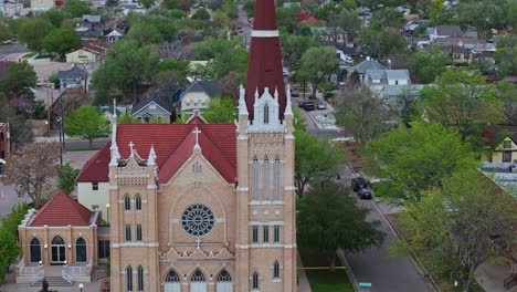 medium closeup aerial orbit around front of arched windows and gothic styled cathedral in pueblo colorado