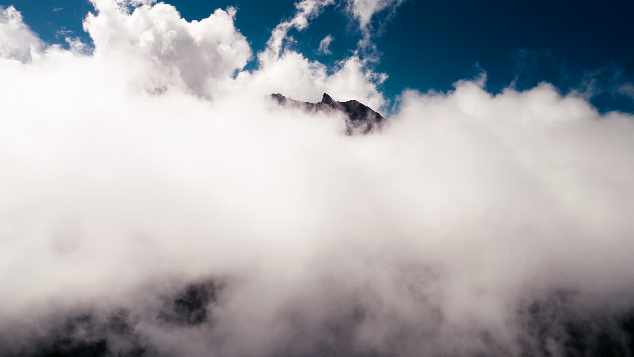 Drone flying through clouds with Mount Agung top in background, Bali in Indonesia