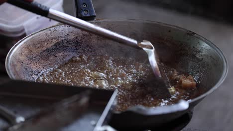 cooking meat in a hot, sizzling frying pan