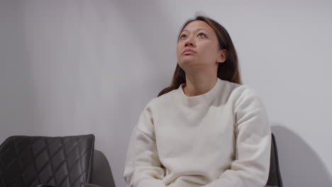 unhappy woman suffering with depression and anxiety sitting in reception of doctor or mental health worker 5