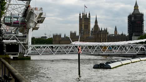 The-London-Eye-spinning-with-the-Palace-of-Westminster-in-the-back-ground,-London,-United-Kingdom