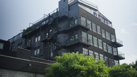 Elegant,-black-painted,-renovated-brick-warehouse-lofts-in-Greenpoint,-Brooklyn,-adorned-with-balconies-and-fire-escapes,-demonstrate-urban-chic