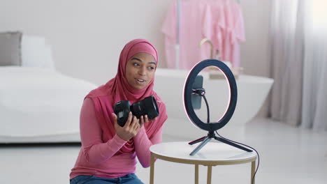 woman in hijab using camera and ring light for video tutorial