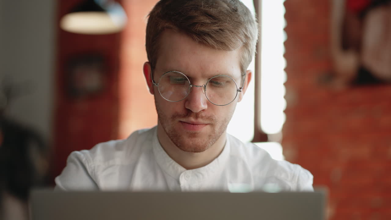 financial analyst is searching info in internet working remotely from cafe typing and looking at display of laptop