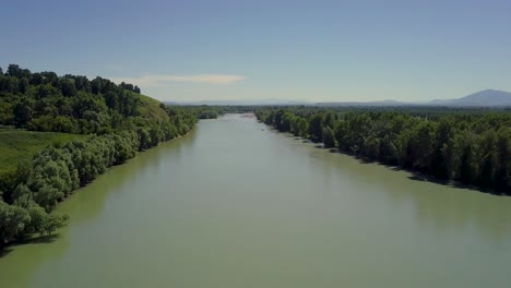 Aerial-Flying-over-the-mountain-river-View-of-the-forest-and-mountains-on-horizon-at-sunset