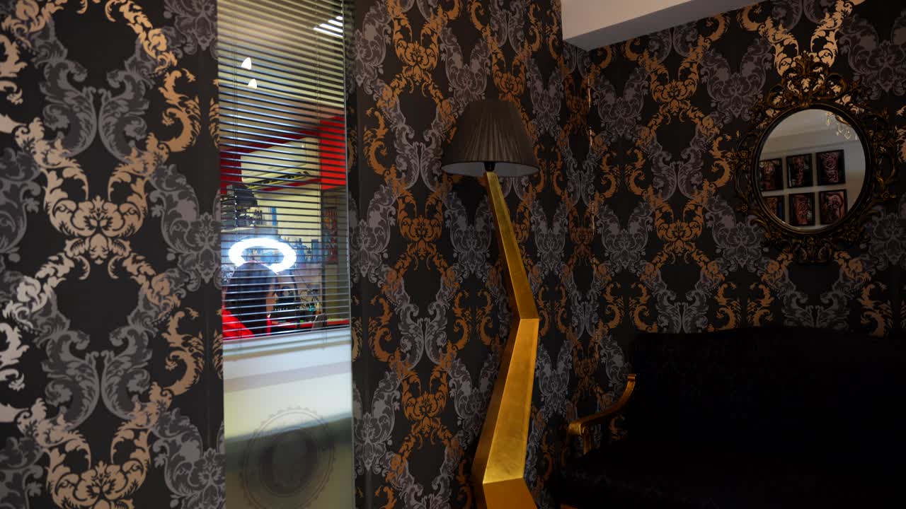 Establisher tilt down interior shot of tattoo studio, client seen through window