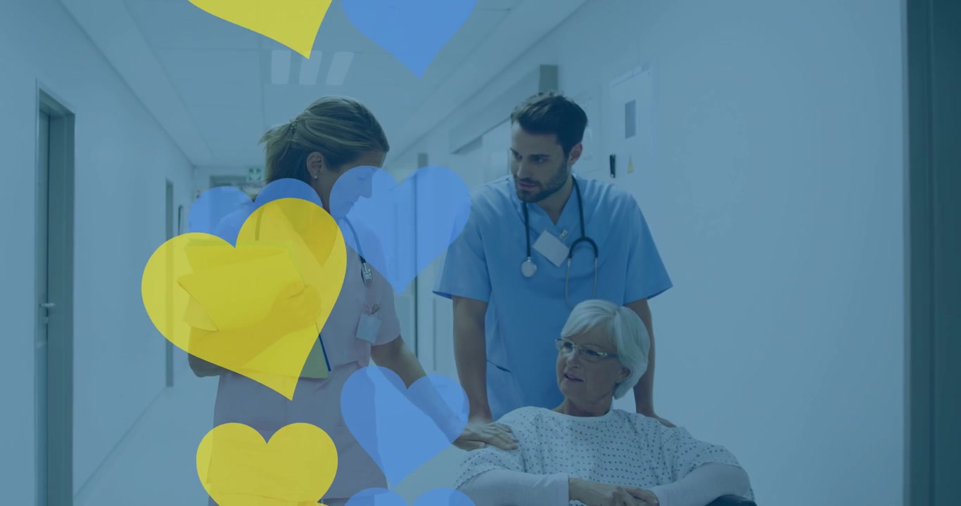 Personale medico che assiste un paziente anziano su una sedia a rotelle in ospedale.