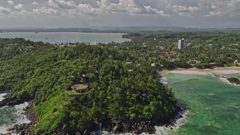 Vuelo-Aéreo-V8-De-Mirissa-Sri-Lanka-Sobre-La-Costa-Alrededor-De-Complejos-Turísticos-En-Las-Laderas-Que-Captura-Paisajes-Rodeados-De-Palmeras,-La-Bahía-De-Weligama-Y-Vistas-Del-Paisaje-Oceánico-Del-Paraíso-Tropical---Filmado-Con-Mavic-3-Cine---Abril-De-2023