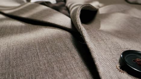 close-up of a beige suit jacket with button detail