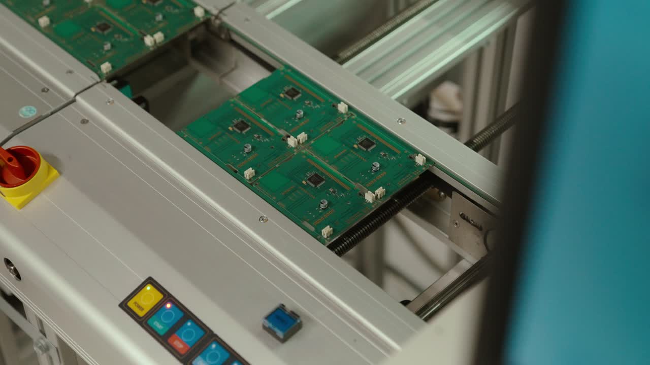 Slow motion circuit boards moving on assembly line in factory setting