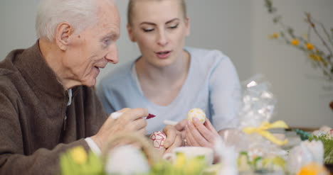 senior man and woman painting easter eggs 4