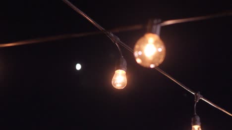 Glühbirnen-Auf-Einem-Draht-Vor-Dem-Hintergrund-Des-Nachthimmels