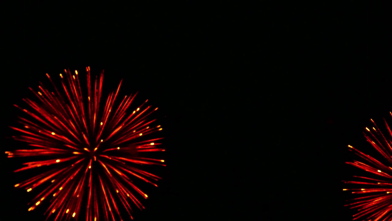 Spettacolari fuochi d'artificio colorati che illuminano il cielo notturno scuro, con scintille radiose, scie luminose e scoppi drammatici che creano un'atmosfera festosa