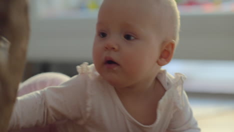 active and curious baby girl playing with wicker interior object at home