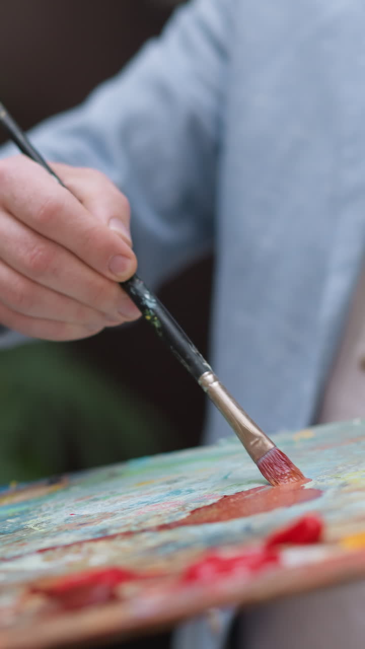 Painter mixes pigments on slab closeup. Inspired designer works with color palette at session in workshop. Professional painter enjoys drawing in studio