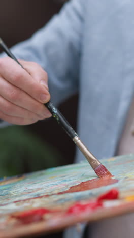 el pintor mezcla pigmentos en el primer plano de la losa. el diseñador inspirado trabaja con la paleta de colores en la sesión en el taller. el pintor profesional disfruta dibujando en el estudio