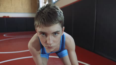 teenage wrestler wearing a blue singlet coming into and going out of focus