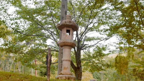 Slide-shot-of-an-old-stone-lamp-outside-a-temple-in-Kyoto,-Japan-4K-slow-motion