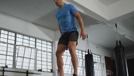 Fit-caucasian-man-jumping-on-pylo-box-at-the-gym