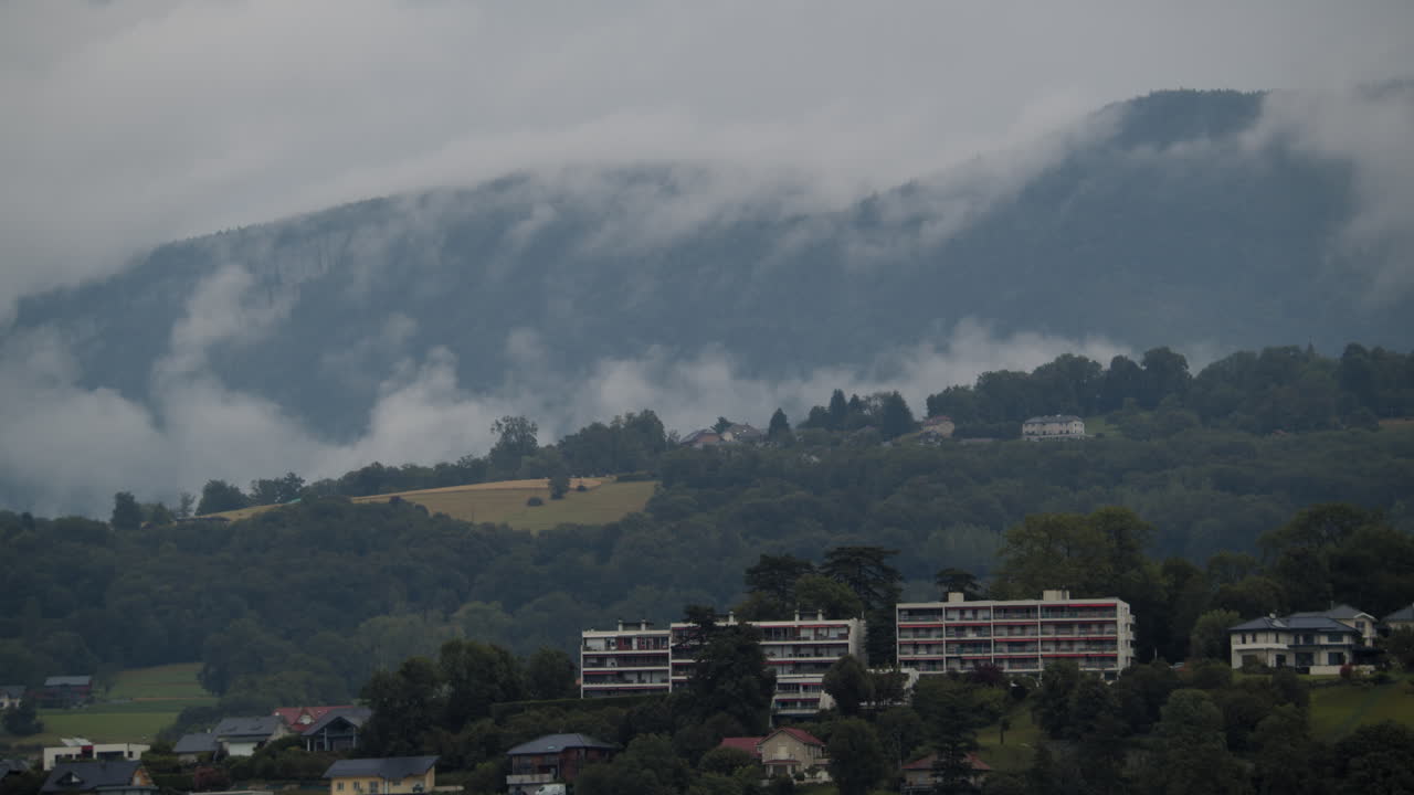 paisaje montañoso brumoso con casas y edificios de apartamentos