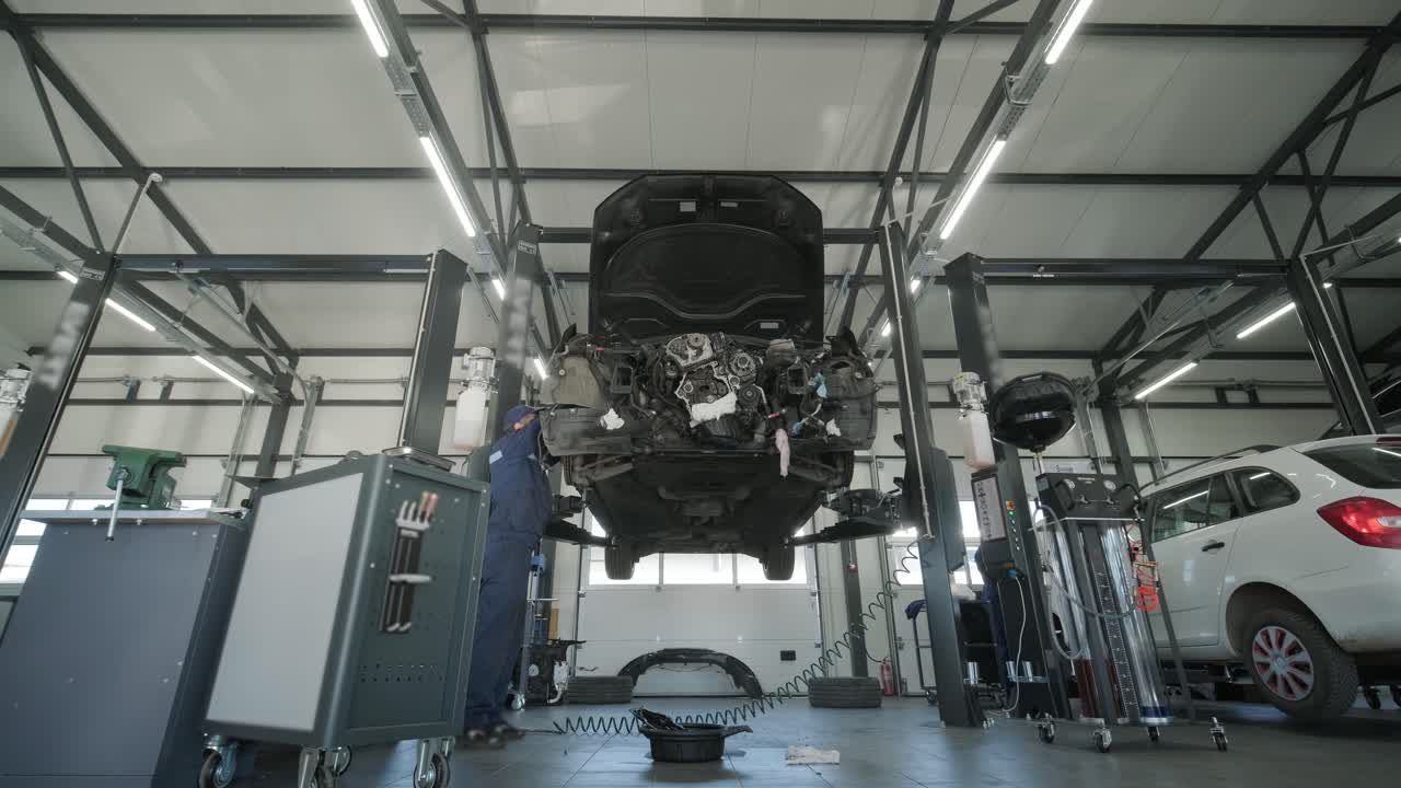 자동차 작업장에서 자동차 엔진을 수리하는 기계공