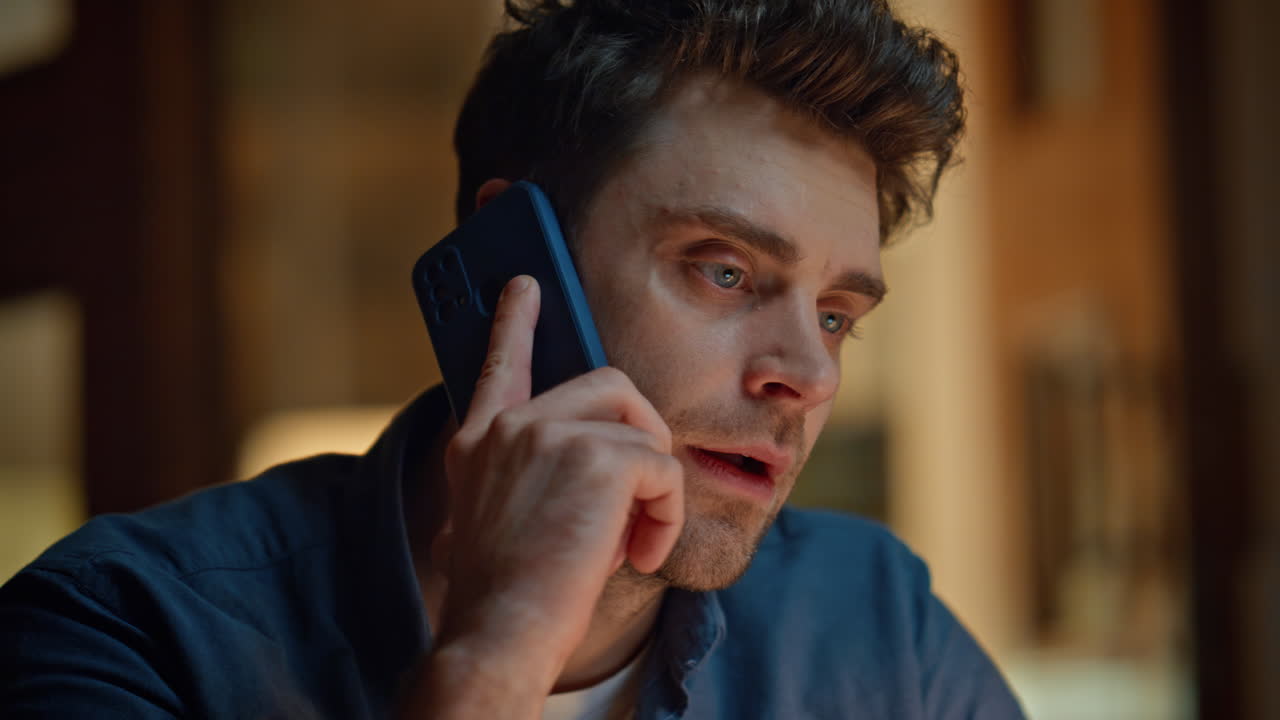 Closeup relaxed businessman calling cellphone at night interior. Man talking