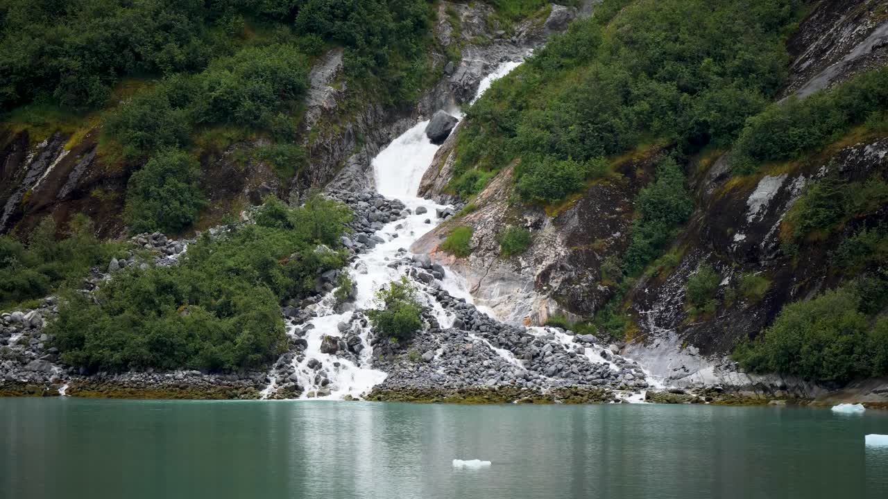 Waterfall's pristine glacial meltwater plunges into tidewater at Endicott Arm fjord, Alaska.