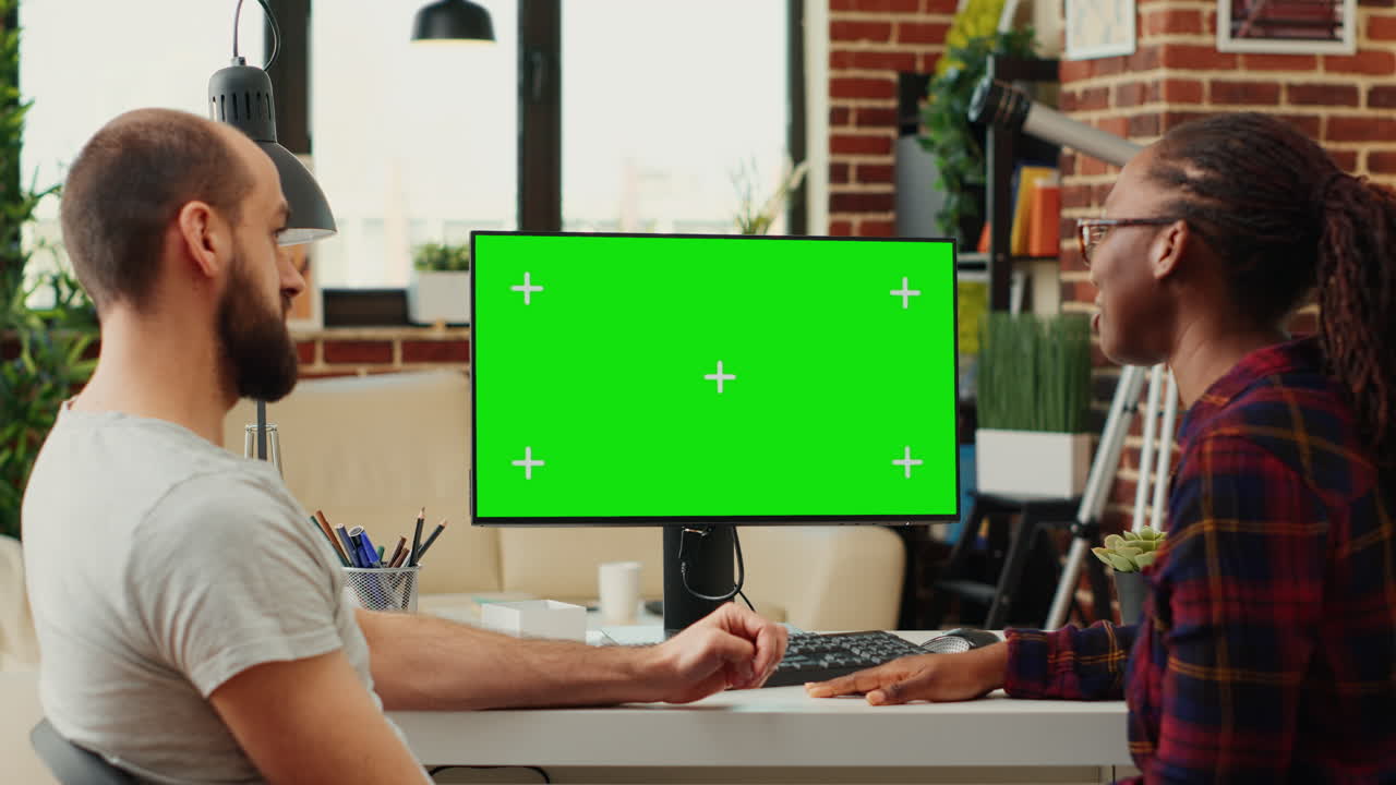 Diverse people working with greenscreen monitor on computer