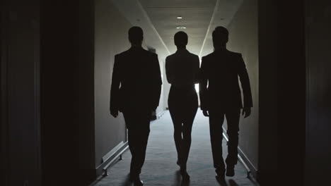 a work team walks in slow motion through a hallway to an important meeting