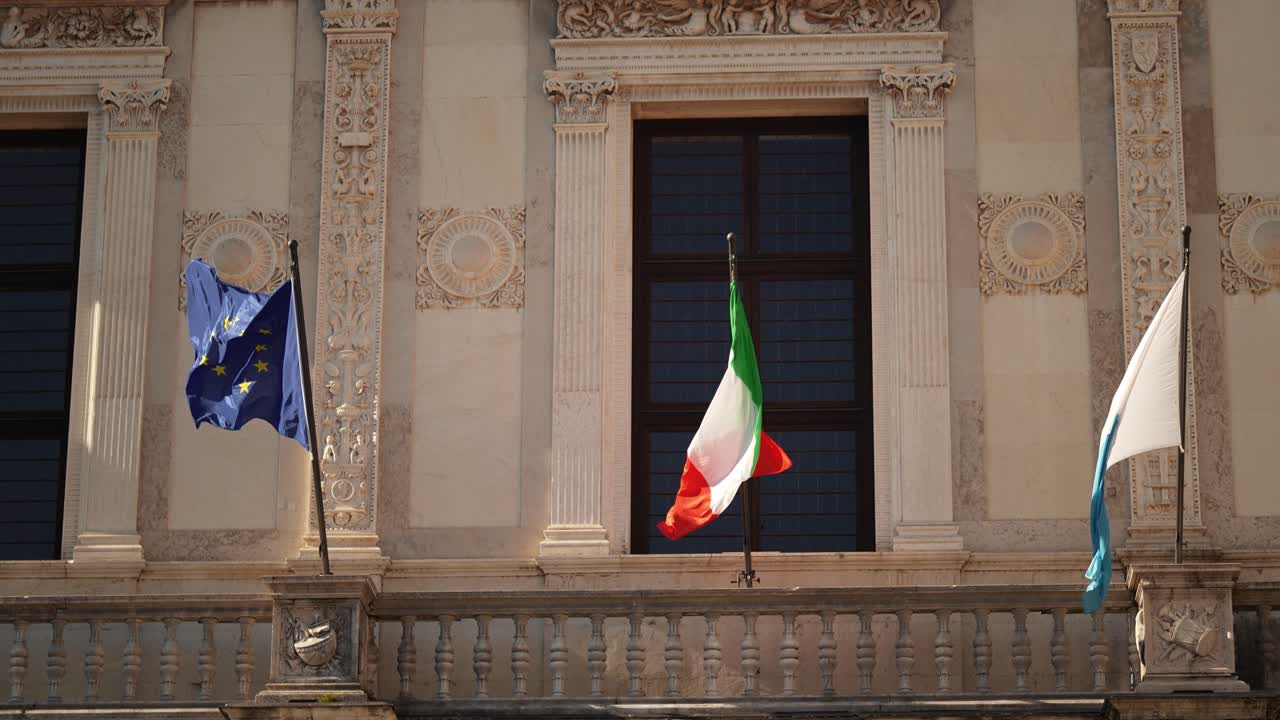 Primo piano del Palazzo della Loggia con le bandiere di Italia, Unione Europea e Lombardia a Brescia, Italia.
