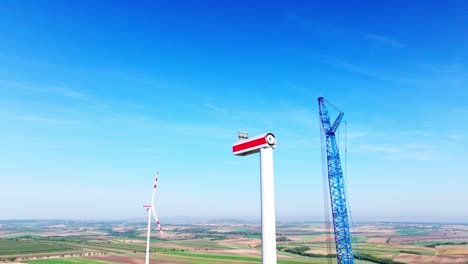 Windmill-Construction-With-Crane-At-Daytime---drone-shot