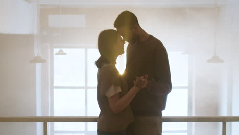 young couple hugging indoors