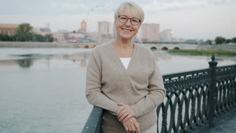 smiling senior woman by the river in city