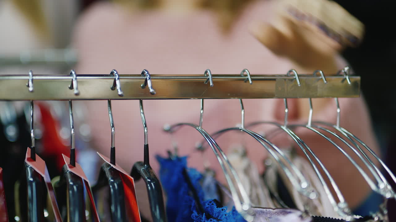 여자는 가게에서 옷을 선택