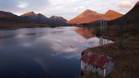 casa de botes junto a un lago durante la puesta de sol