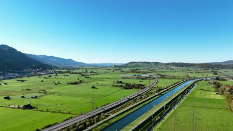 Vista-Aérea-De-La-Campiña-Suiza-Sobre-El-Río-Linth-En-Suiza