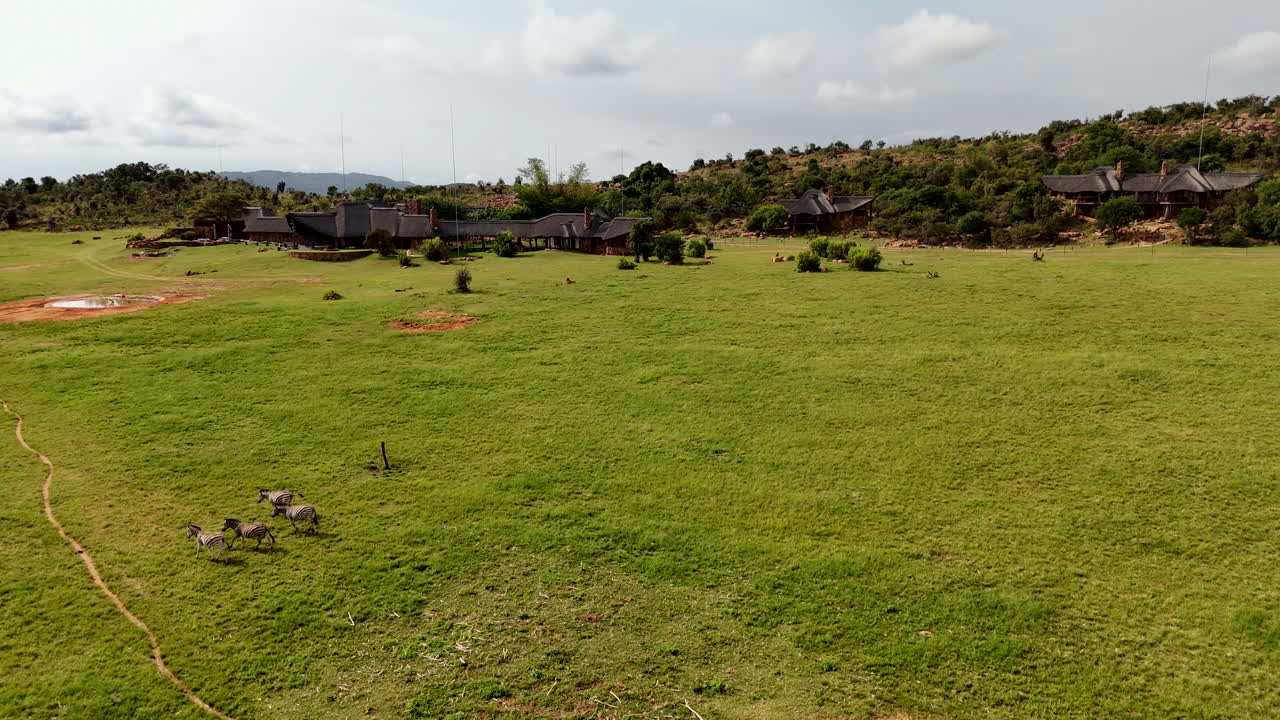 Lodge de safari de lujo en las llanuras africanas, capturado por un dron 4K en una toma panorámica.