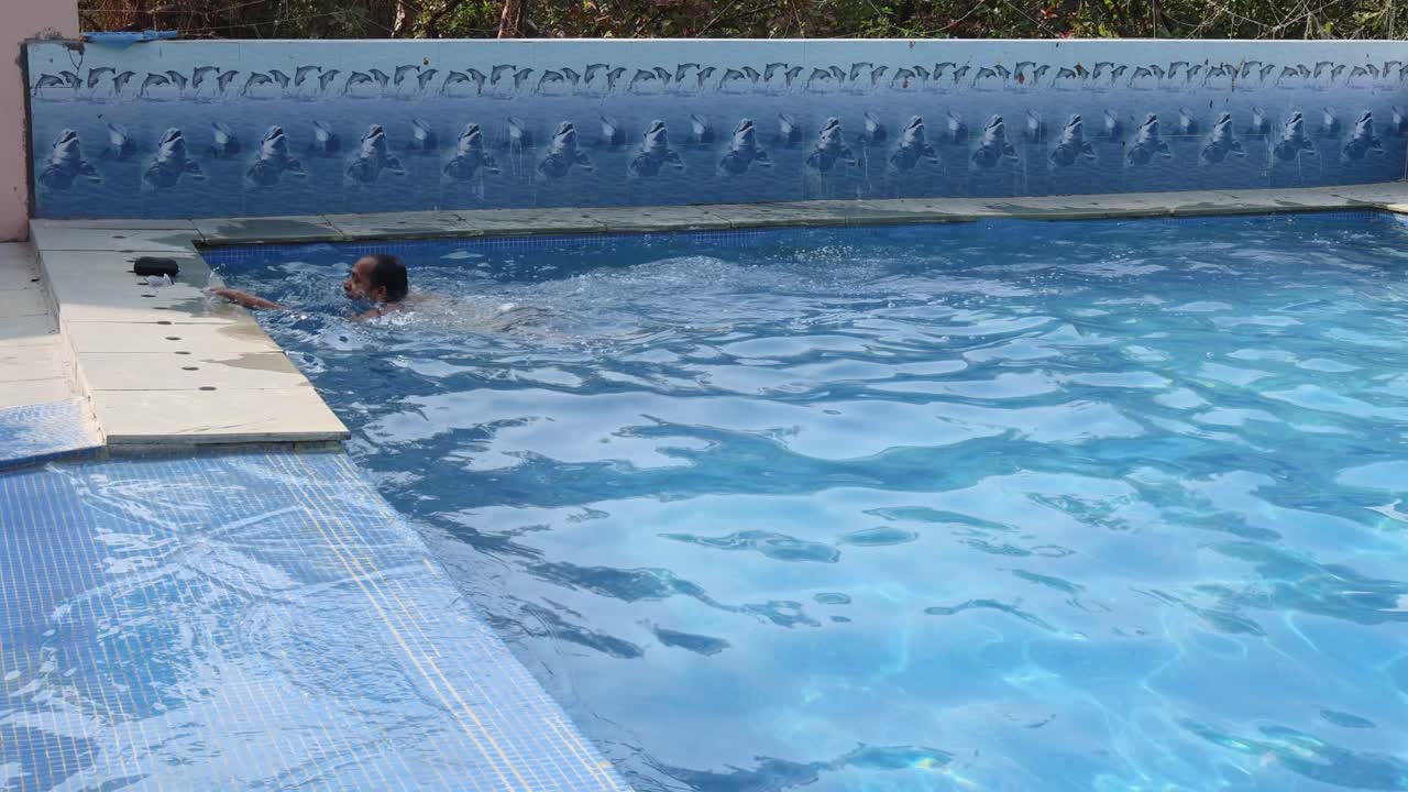 joven aislado nadando en una piscina con agua clara por la mañana