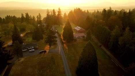 cinematic sunset drone shot in forest with a remote residential house with sun rays peaking beautiful aerial 4k filmed in renton washington