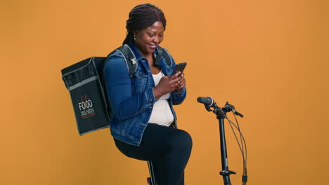 female with bag uses mobile for delivery