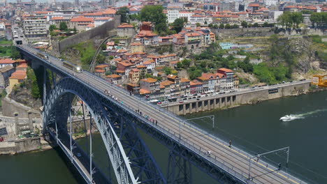 aerial footage of douro riverside rotating over the dom luís i bridge in porto city, portugal