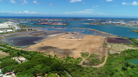 cloud shadows pass on tropical seaport industrial zon, asphalt lake and harbor, panoramic aerial