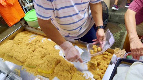 Close-up-shot-of-a-Malaysian-hawker's-hands-packing-snacks-before-selling-in-a-roadside-stall-in-Kuala-Lumpur