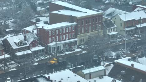 driving truck on road of small american town during snowstorm on winter day